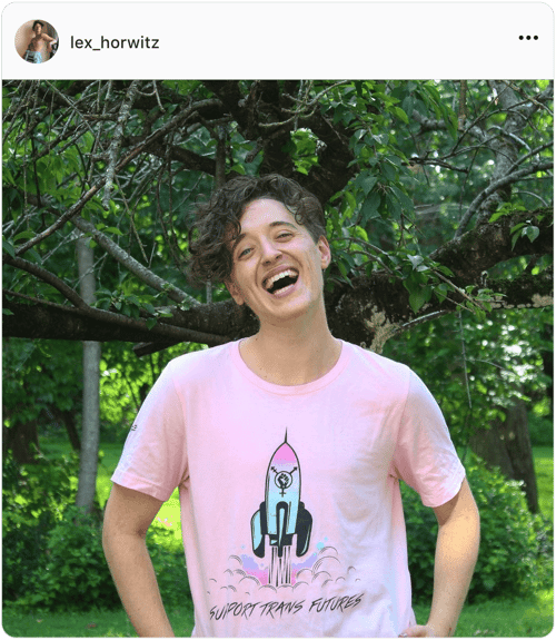 Influencer Lex Horwitz smiles at the camera wearing a pink t-shirt with the phrase Support Trans Futures