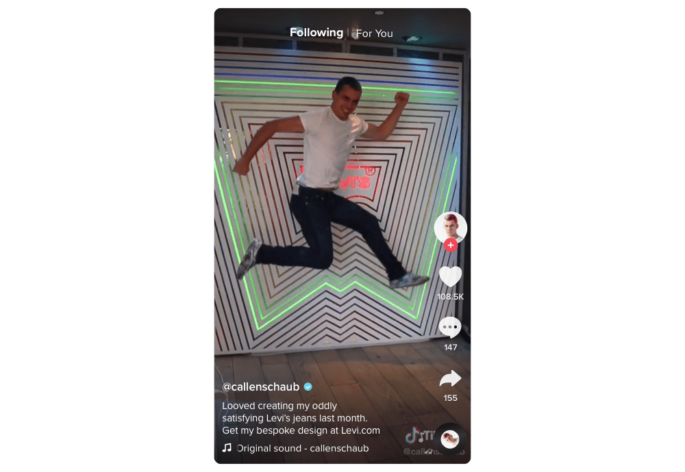 TikTok screenshot, man jumps excitedly in front of a wall