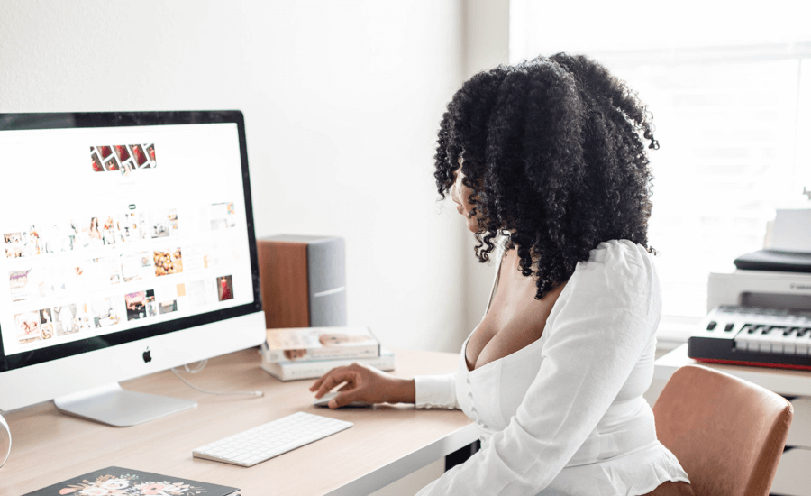 A woman is sitting at a desk facing a computer screen