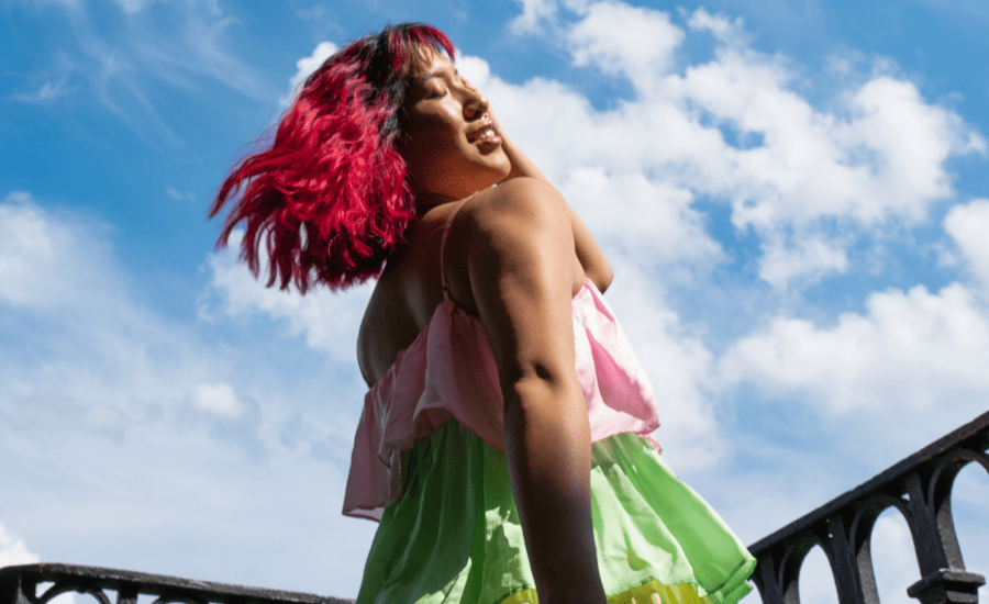Person with coloured hair spins facing the sky