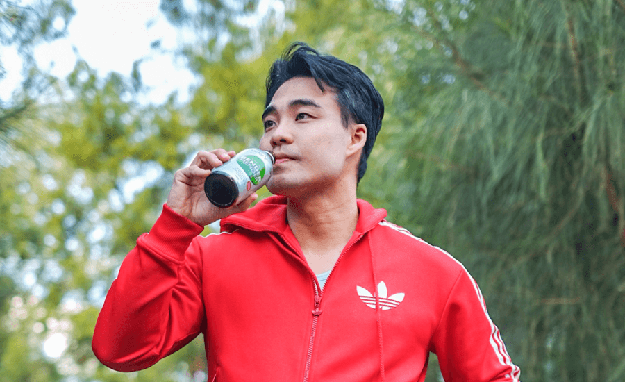 Man in a red tracksuit takes a drink