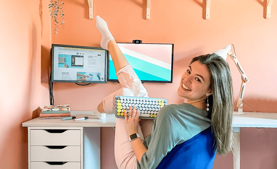 woman turned around at her desk smiling at the camera with a leg in the air