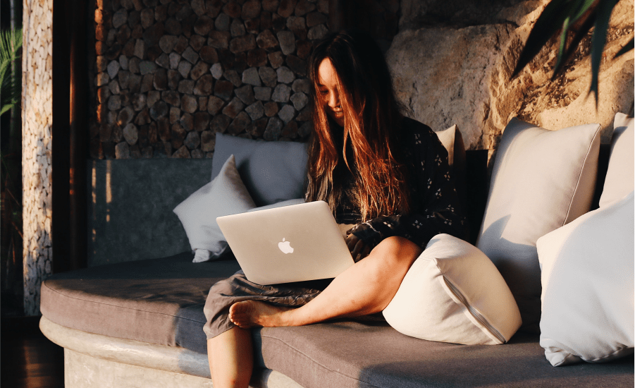 woman sits on her laptop in the sun