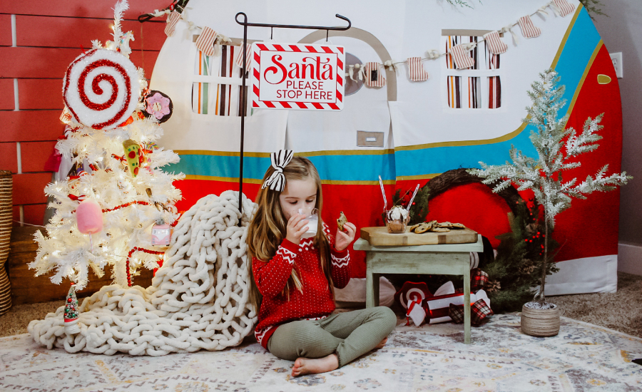 A young girl in front of Christmas decorations