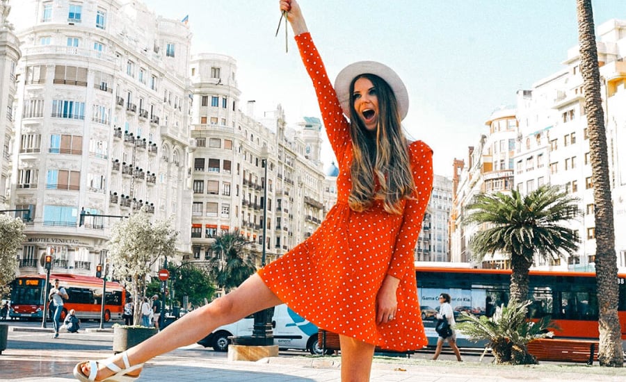 An image of a TRIBE creator wearing a red dress in a paid partnership post for Olay